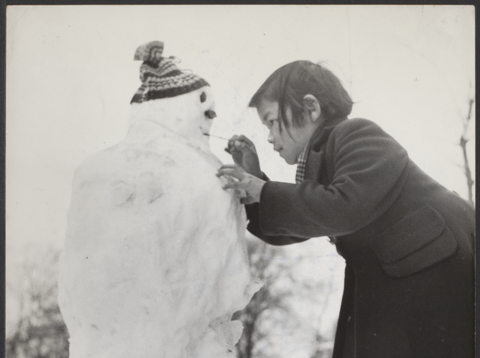 Een meisje in de weer met een sneeuwpop