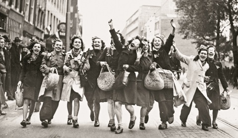 Groep vrouwen host arm in arm over het Vredenburg in Utrecht op de dag van de bevrijding