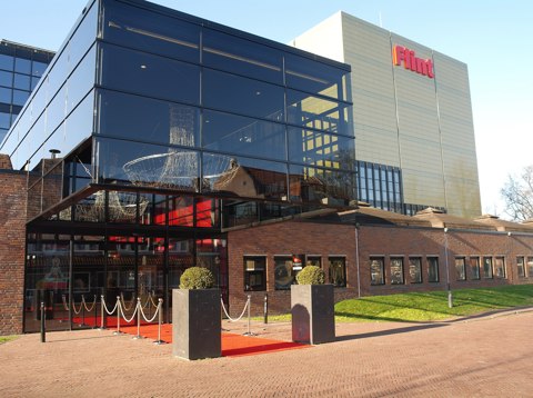Voorgevel van Flint Amersfoort, met op de voorgrond de ingang en bakstenen 'huisjes' van het oorspronkelijke ontwerp. Daarachter nieuw gebouwde onderdelen van glas en andere materialen, die zijn aangebracht na de brand van 1990.